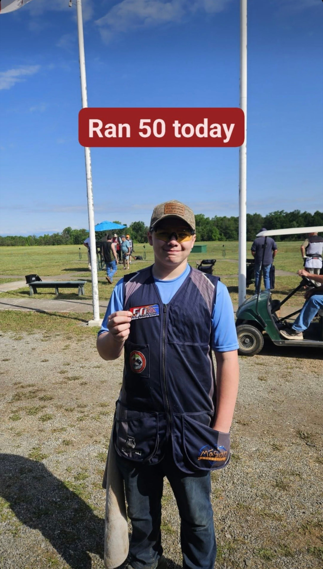 Shooter holding a 50 straight patch after a perfect round at the trap field
